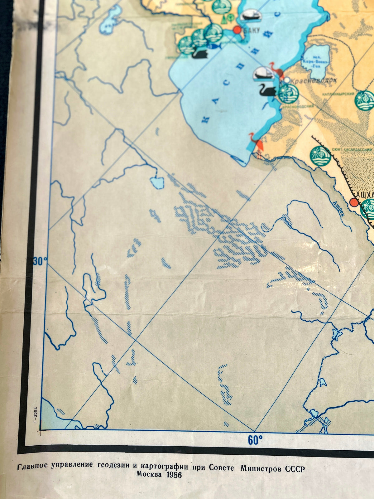 A close-up of a vintage map "Nature protection in the USS" showing coastal geography with blue water, beige land, and grid lines.