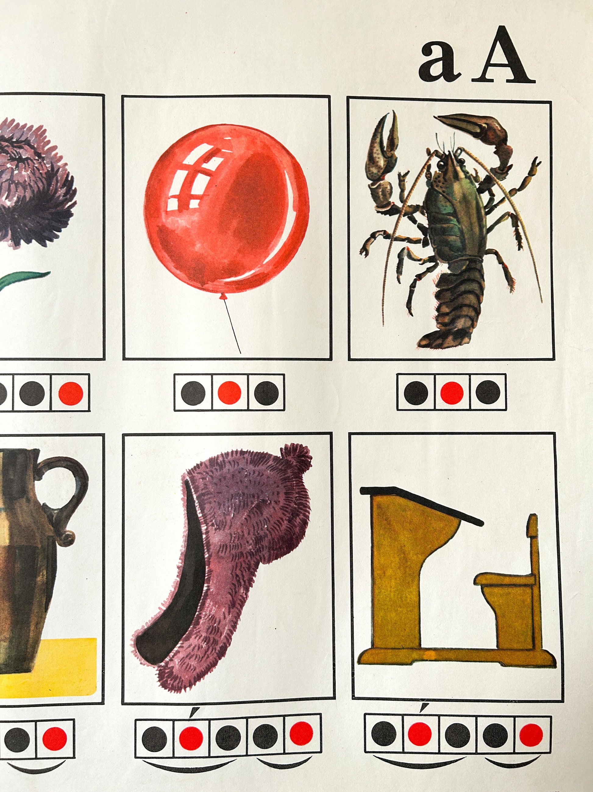 Detail of a vintage USSR children's phonetic alphabet poster showing the letter 'A' with six illustrated word-starter images: a flower, a red balloon, a crayfish, a jug, a fuzzy purple hat, and a school desk. Each panel includes a phonetic diagram underneeth.