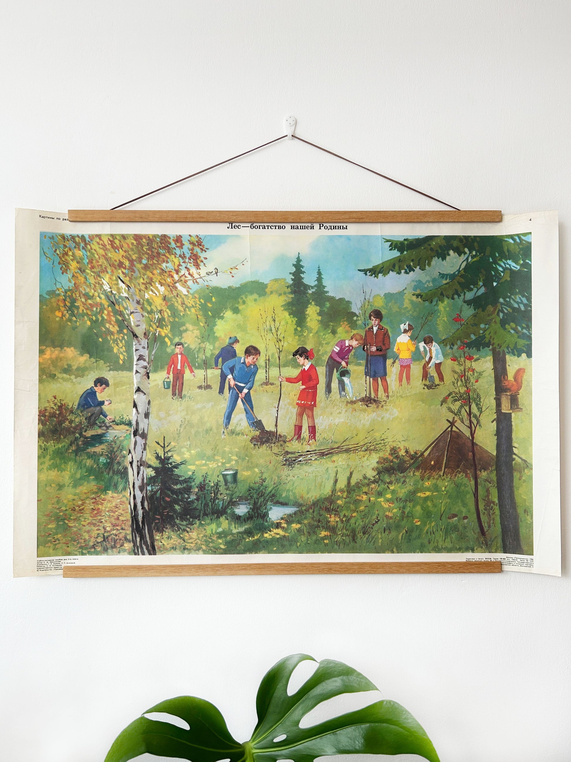 Soviet vintage educational school poster on the importance of looking after the woodland, depicting a group of children planting trees in a forest clearing.