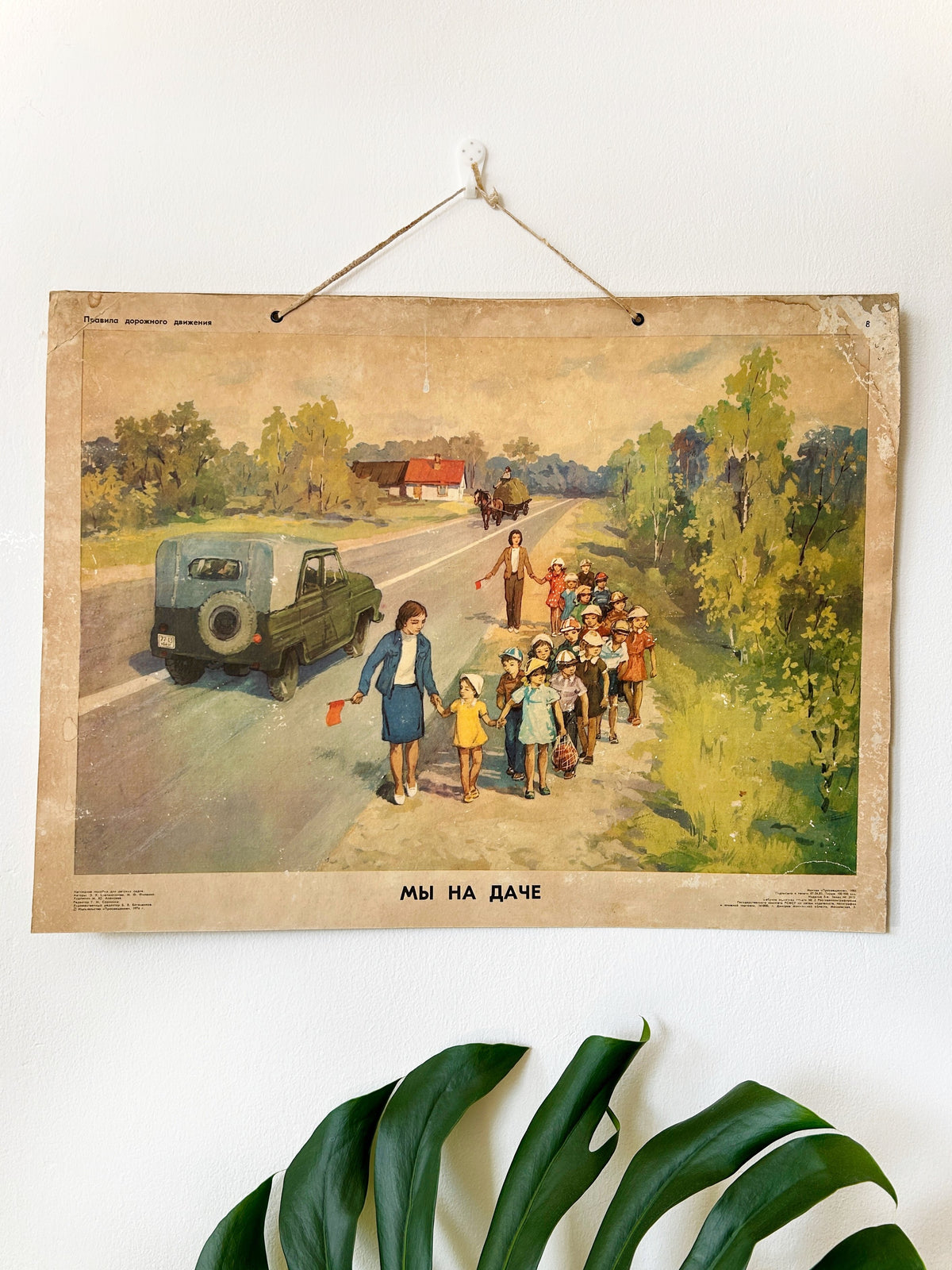 USSR vintage illustrated nursery road safety poster showing correct behaviour by a countryside road without a pavement: teachers guiding children along the road with flags.