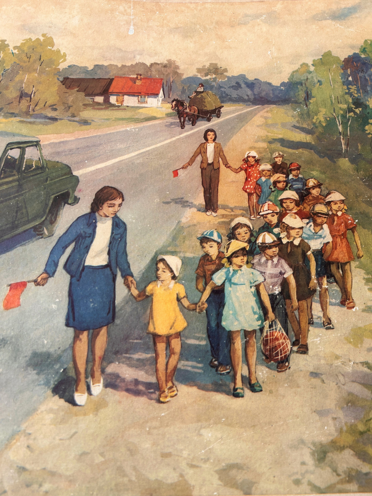 Detail of a vintage USSR illustrated road safety poster: a countryside scene showing a group of children and teachers walking along a country road, with a horse-drawn carriage in the distance, houses, trees, and a car on the left. 