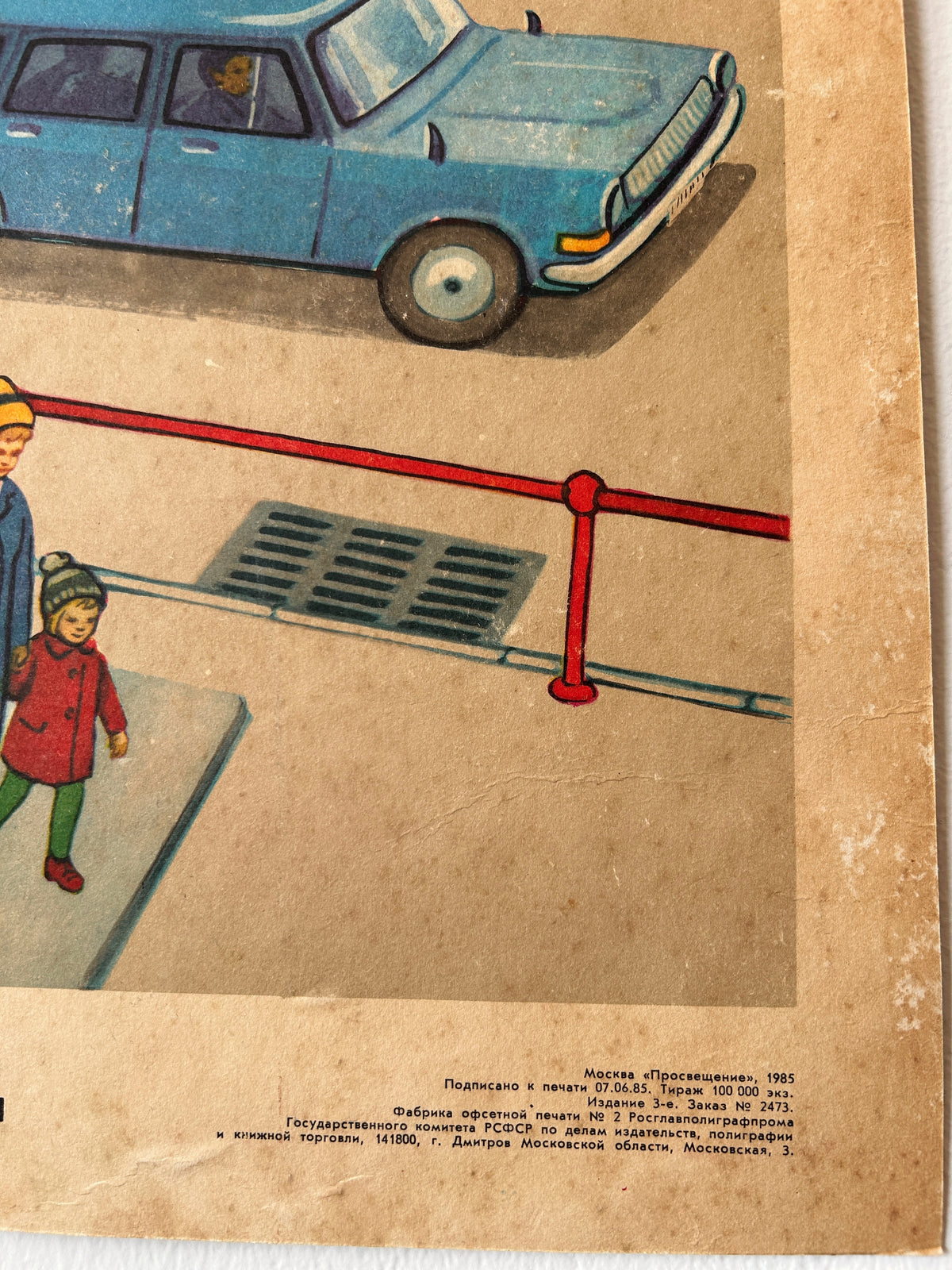 Detail of a vintage USSR illustrated road safety poster: a street scene showing a parent and a child coming out of an underground pedestrian crossing with a car in the background and printed text with typography information.