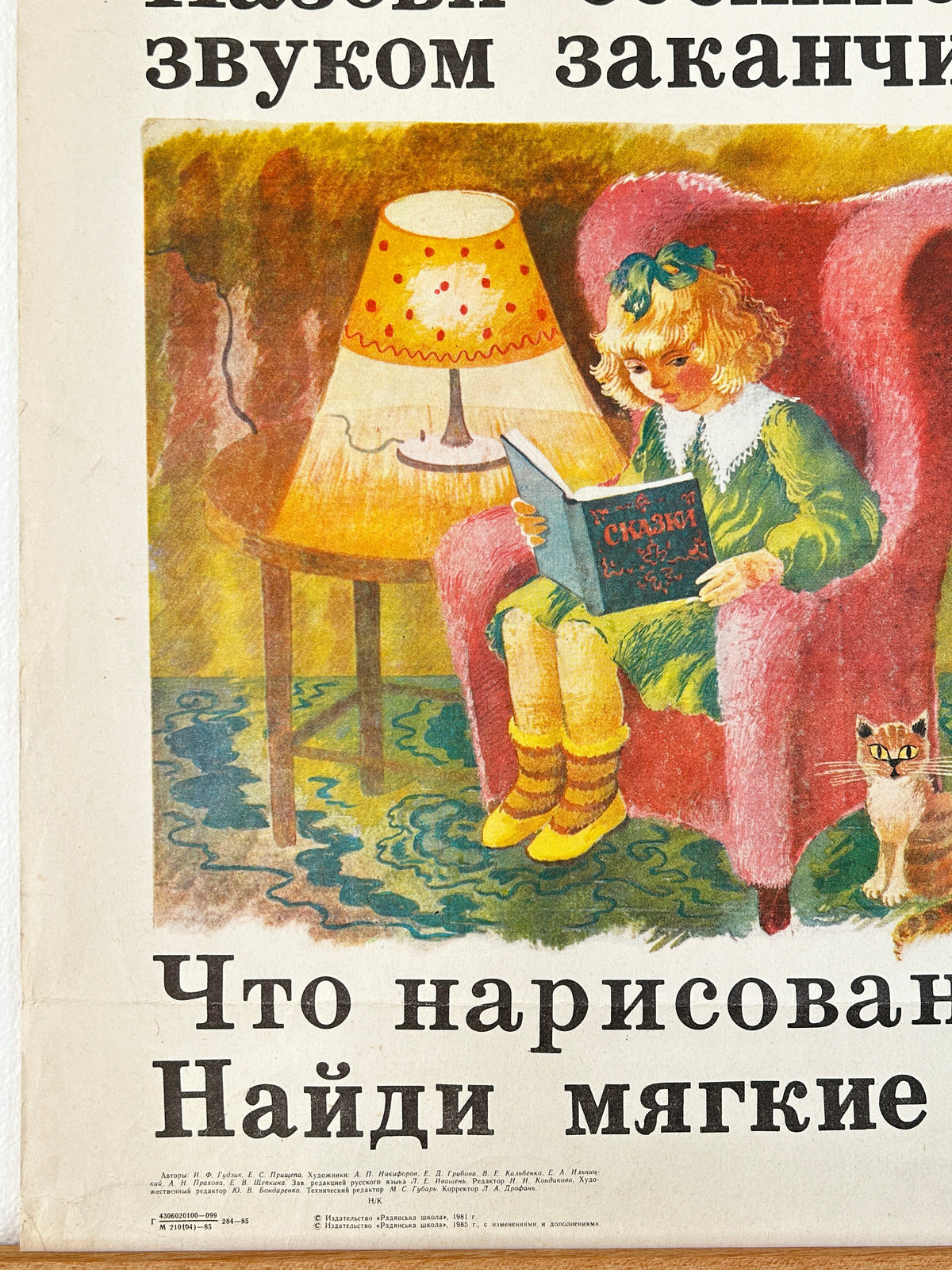 Detail of a USSR vintage school poster featuring an illustration of a young girl reading in a pink armchair beside a lamp, with large russian text at the top and bottom.