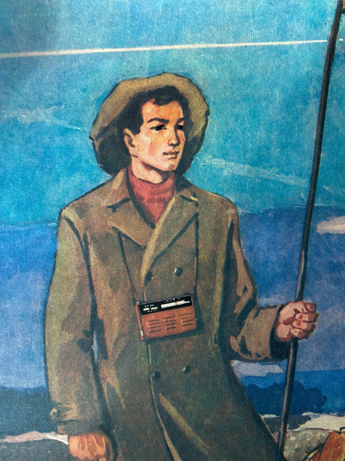 Close-up detail of a Soviet vintage poster depicting a shepherd with a radio around his neck wearing a coat and a wide brim hat.